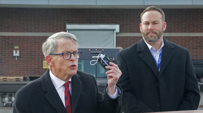 Gov. Mike DeWine reminds residents that they still need to wear a mask as Springfield Regional Medical Center President Adam Groshans listens shortly after the first vaccine arrives at the hospital. BILL LACKEY/STAFF