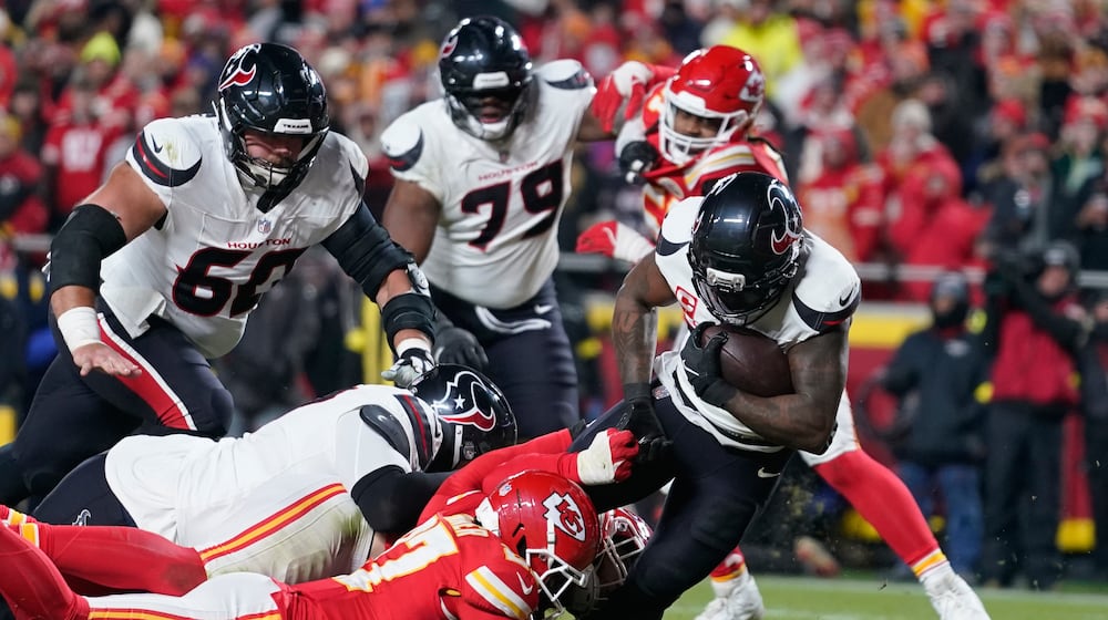 Houston Texans running back Dare Ogunbowale, right, scores past Kansas City Chiefs defensive back Chamarri Conner during the second half of an NFL football game Wednesday, Jan. 7, 2026, in Kansas City, Mo. (AP Photo/Ed Zurga)