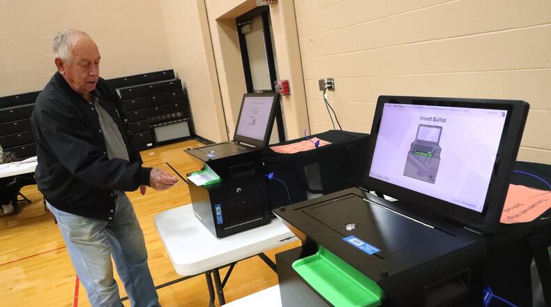 Robert Bechtle places his ballot in the new ballot machines at the New Carlisle election poll in the Tecumseh High School gym Tuesday. BILL LACKEY/STAFF