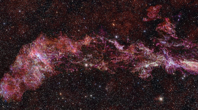 This image provided by the European Southern Observatory shows the complex distribution of molecular gas in the Central Molecular Zone (CMZ) of the Milky Way, designated in different colors: sulphur monoxide (cyan), silicon monoxide (green), isocyanic acid (red), cyanoacetylene (blue), and carbon monosulphide (magenta). The stars in the foreground of this image were observed at infrared wavelengths (Y, Z and J filters). (ALMA(ESO/NAOJ/NRAO)/S. Longmore via AP)