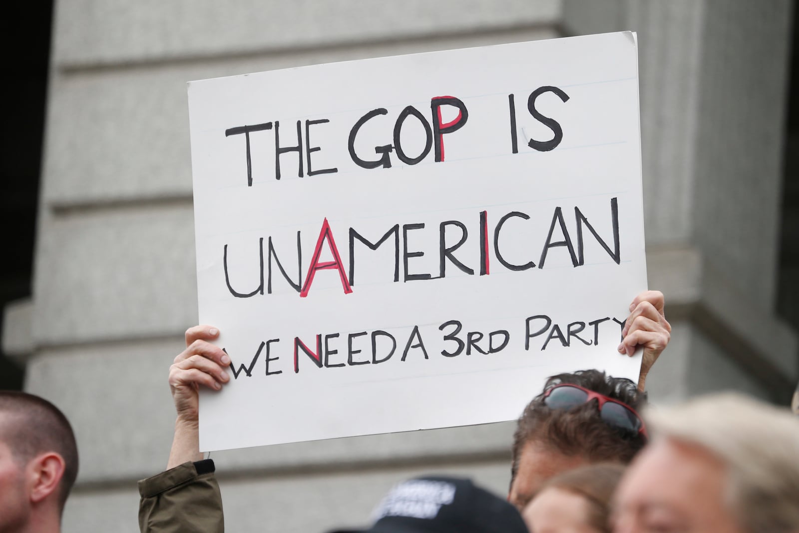 FILE - An unidentified protester holds up a placard as supporters of the Republican presidential candidate Donald Trump demonstrate on the steps of the Colorado State Capitol, April 15, 2016, in downtown Denver. (AP Photo/David Zalubowski, File)