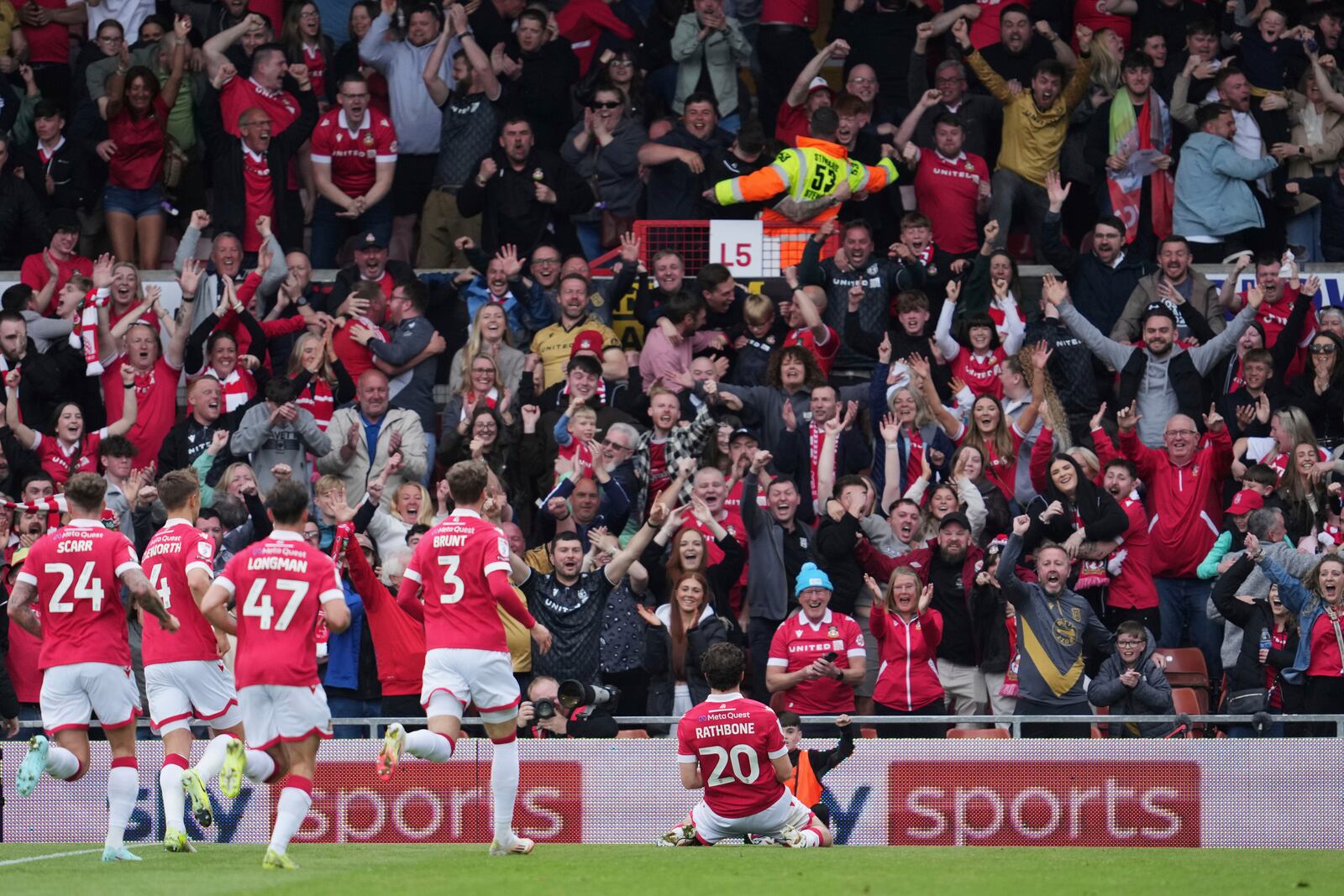 Wrexham's Oliver Rathbone, right, celebrates with teammates after scoring his side's opening goal during the English League One soccer match between Wrexham and Charlton Athletic at the Racecourse ground in Wrexham, Wales, Saturday, April 26, 2025. (AP Photo/Jon Super)
