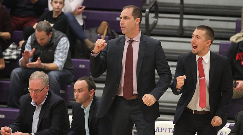 Wittenberg coach Matt Croci, center, celebrates a basket against Capital on Nov. 29. David Jablonski/Staff