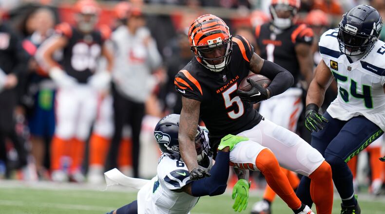 Cincinnati Bengals' Tee Higgins (5) is tackled by Seattle Seahawks' Quandre Diggs (6) during the first half of an NFL football game, Sunday, Oct. 15, 2023, in Cincinnati. (AP Photo/Michael Conroy)