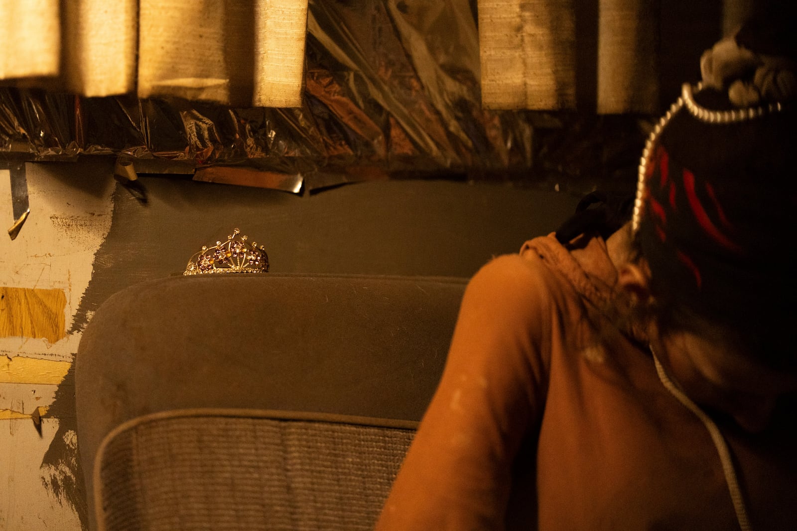 A tiara rests on a seat as a woman writes in a journal at a homeless encampment in Deschutes National Forest Wednesday, April 30, 2025 near Bend, Ore. (AP Photo/Jenny Kane)