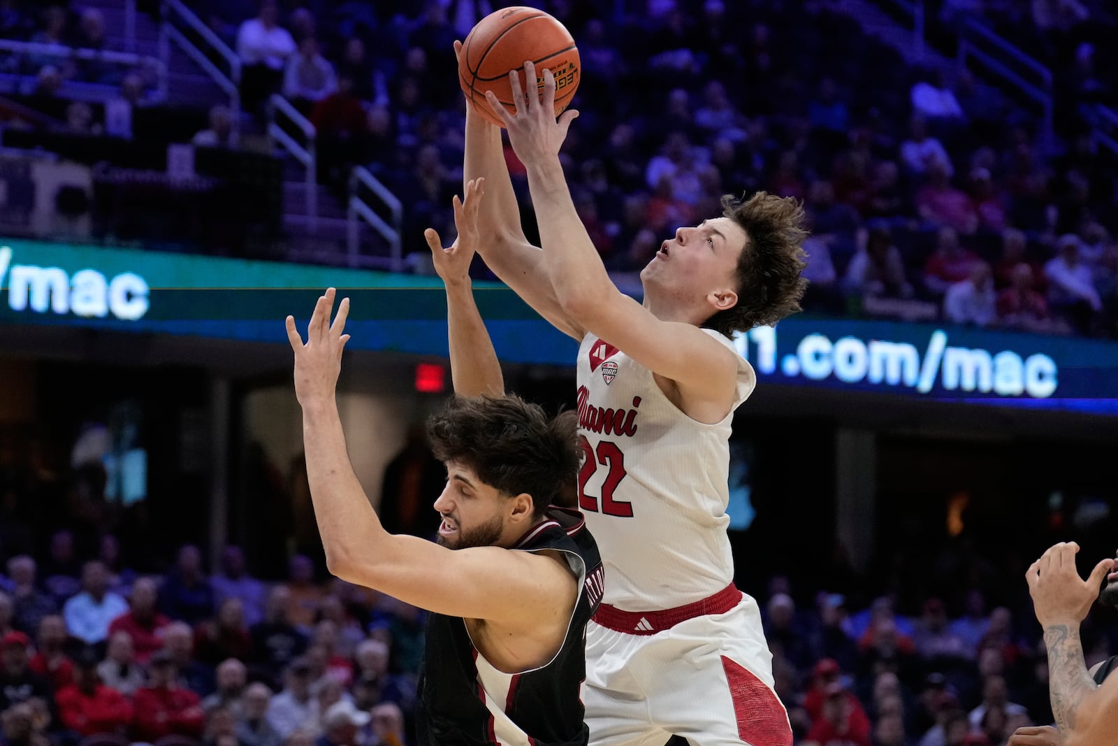 Miami (Ohio) forward Brant Byers (22) grabs a rebound behind Massachusetts forward Leonardo Bettiol, left, in the second half of a basketball game in the quarterfinals of the Mid-American Conference tournament, Thursday, March 12, 2026, in Cleveland. (AP Photo/Sue Ogrocki)
