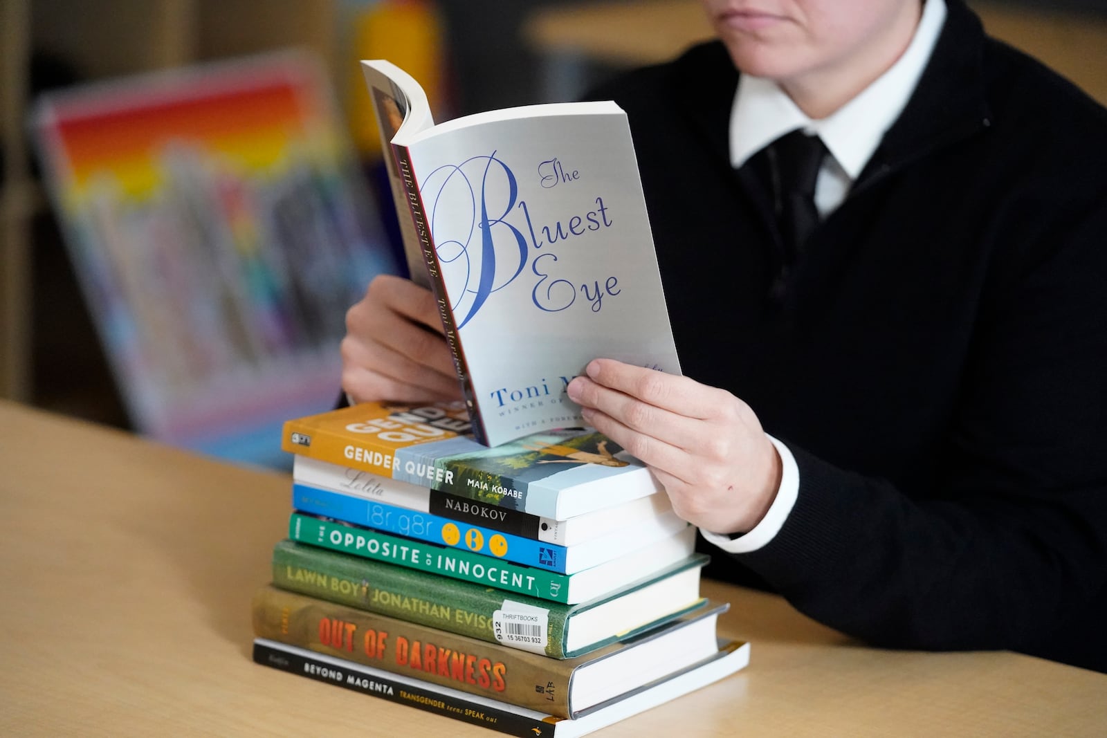 Amanda Darrow, director of youth, family and education programs at the Utah Pride Center, poses with books, including "The Bluest Eye," by Toni Morrison. (AP Photo/Rick Bowmer, File)