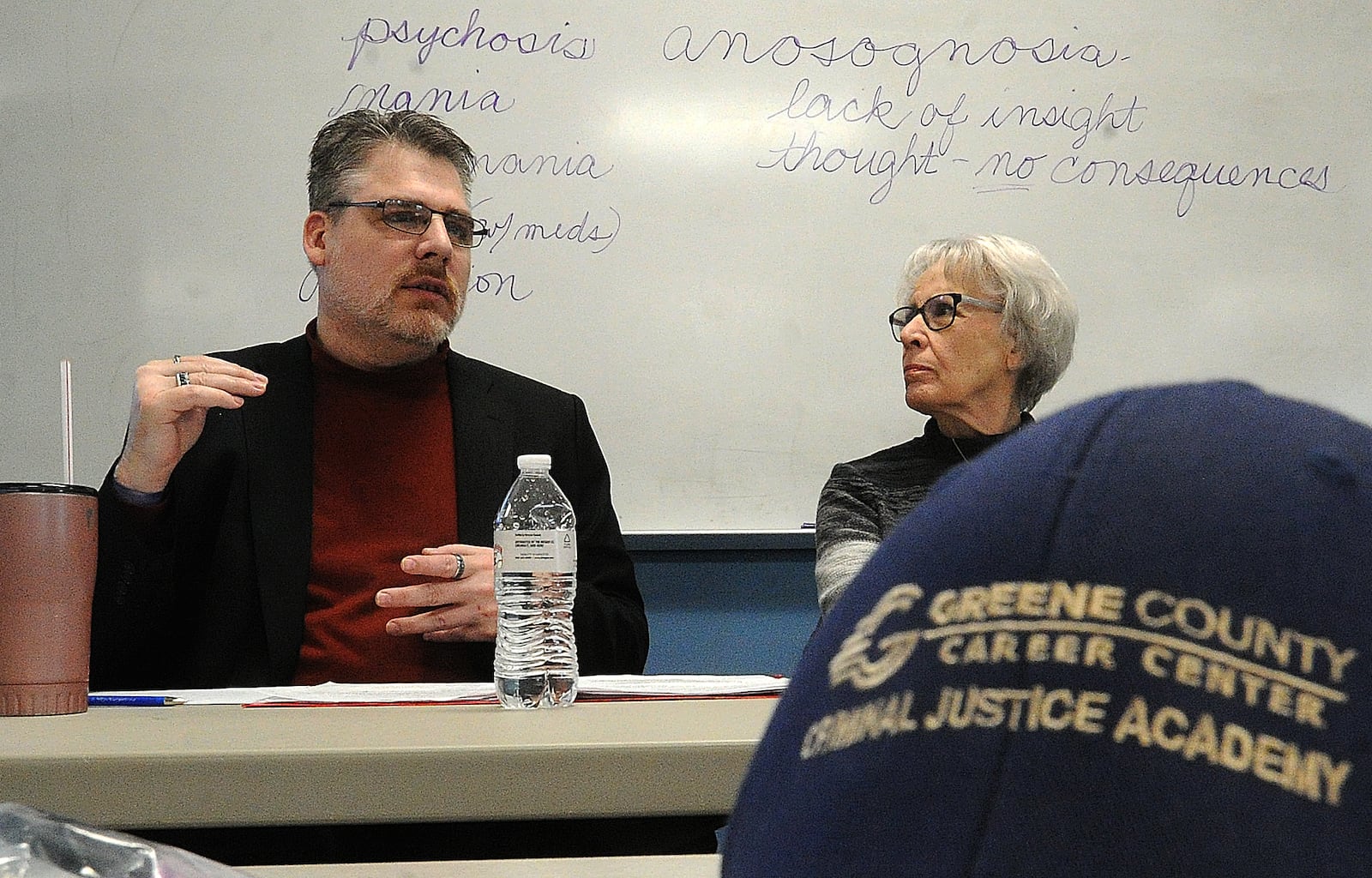 Evan Curtin (left) and his mother Peg Stephens talk to law enforcement about crisis training focused on mental health, March 16, 2023 at the Greene County Criminal Justice Academy. Curtin has had more than 50 encounters with police, many while having mental health issues. STAFF / FILE