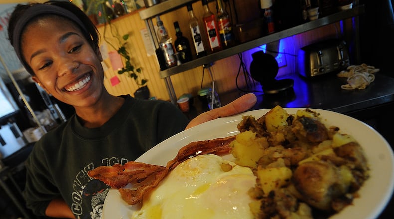 Briana Beauzile an employee of the Butter Cafe, prepares to serve a guest two eggs, bacon and butter potatoes. MARSHALL GORBY\STAFF