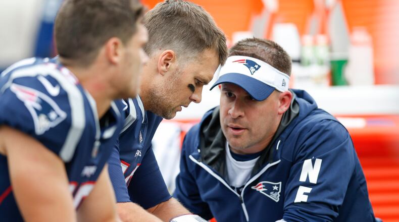 New England Patriots quarterback Tom Brady (12) talks with offensive coordinator Josh McDaniels during the second quarter against the Houston Texans at Gillette Stadium.