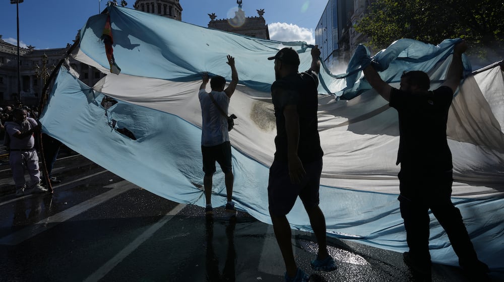 Protesters rally during a march by trade unions and opposition groups against a labor reform bill proposed by President Javier Milei's government in Buenos Aires, Argentina, Thursday, Feb. 19, 2026. (AP Photo/Rodrigo Abd)