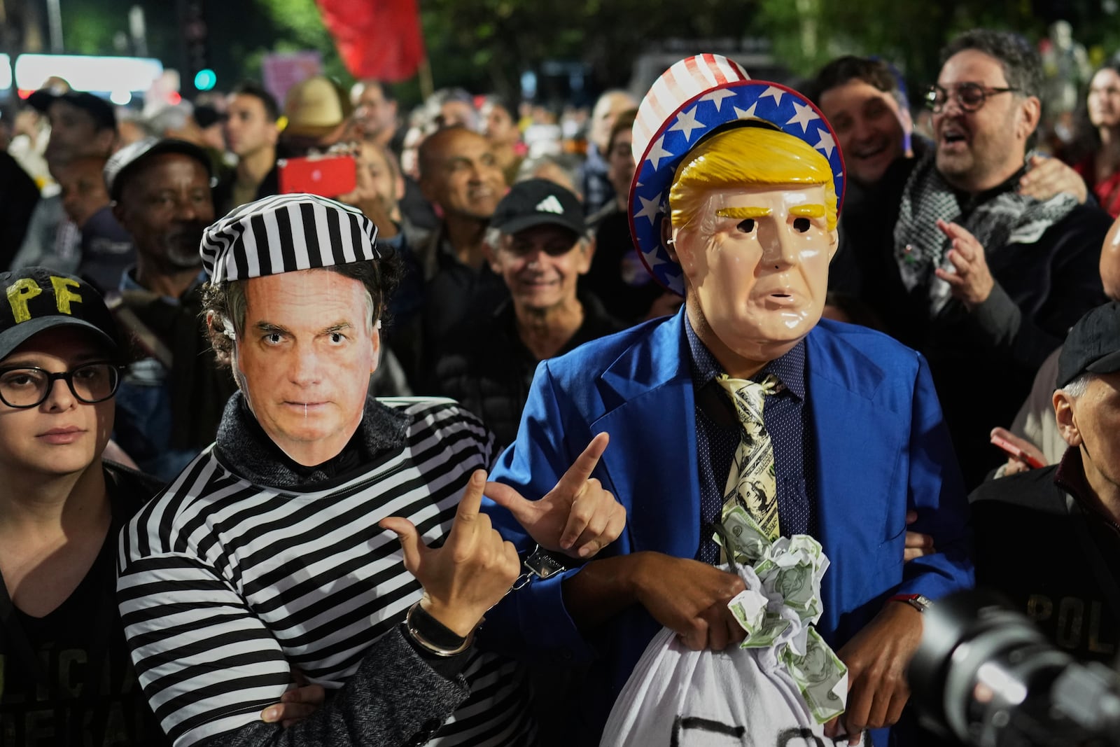 Protesters wearing masks of U.S. President Donald Trump, right, and former President of Brazil Jair Bolsonaro demonstrate after Trump's announcement of 50% tariffs on Brazilian goods, in Sao Paulo Thursday, July 10, 2025. (AP Photo/Andre Penner)