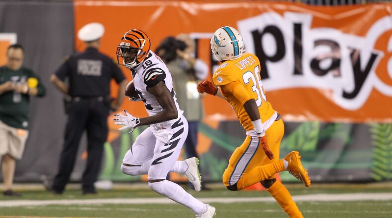 A.J. Green of the Bengals attempts to run the ball past Tony Lippett of the Dolphins during a game last September at Paul Brown Stadium.