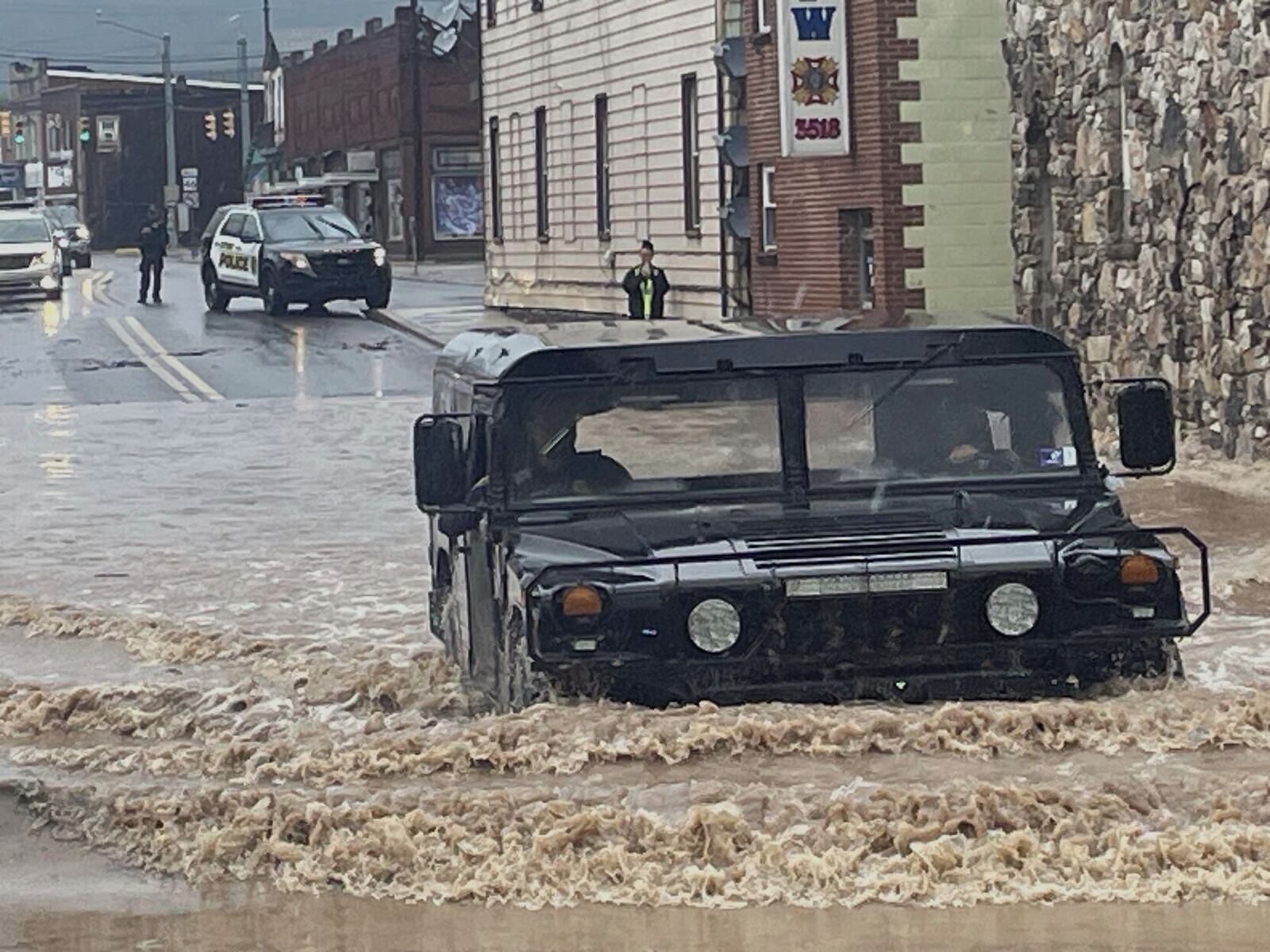 A Keyser Police Department Humvee crosses high water at the intersection of Water and Armstrong streets in Keyser, W.Va., after flash flooding Tuesday, May 13, 2025. (John D. Smith/Cumberland Times-News via AP)