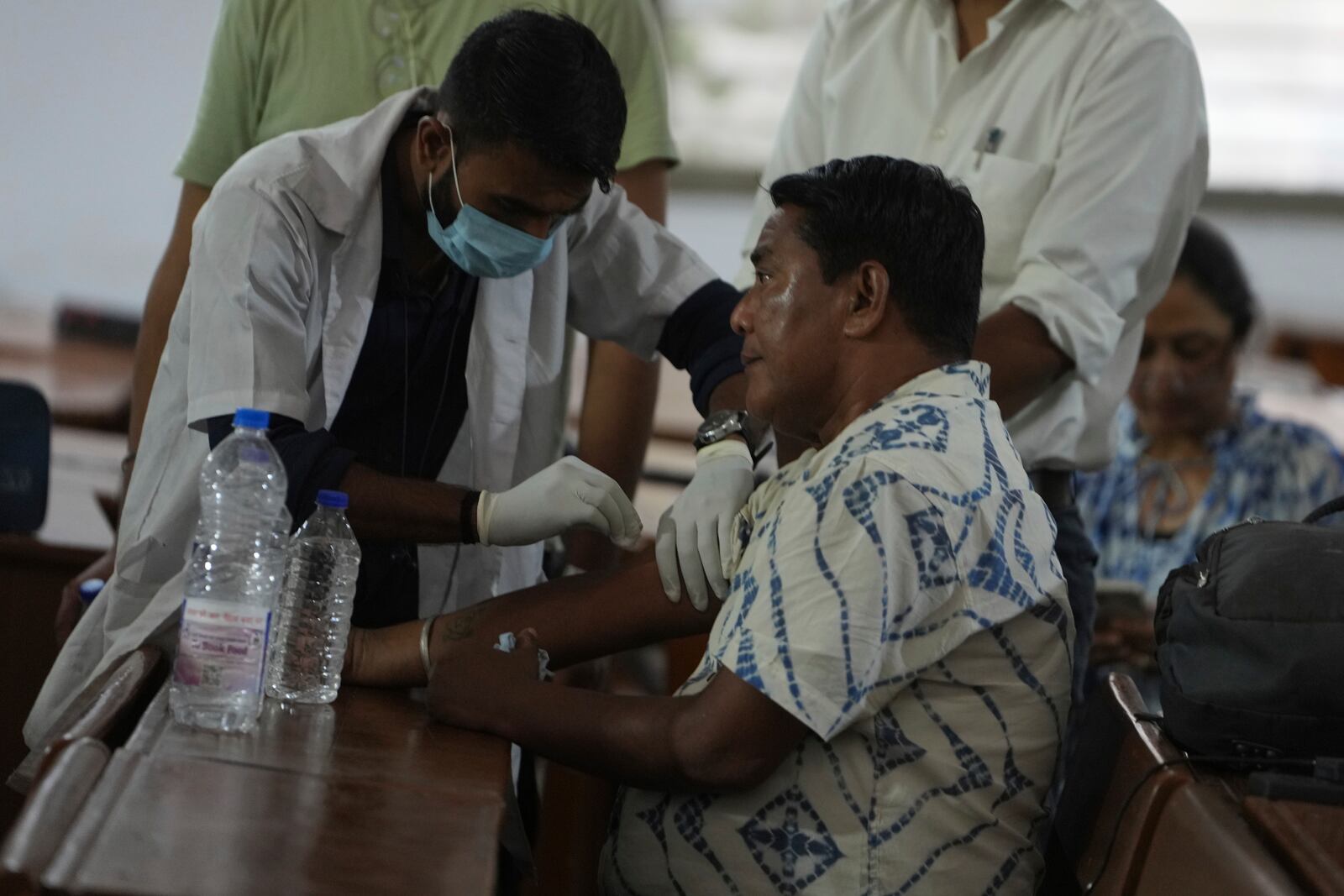 A health worker take DNA sample of a family member of a victim of an airplane that crashed in India's northwestern city of Ahmedabad in Gujarat state, Friday, June 13, 2025. (AP Photo/Ajit Solanki)