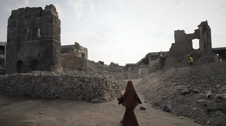 A Palestinian woman walks past the historic Pasha Palace in Gaza City after an Israeli airstrike badly damaged the building during the war in the Gaza Strip, Thursday, Nov. 13, 2025. (AP Photo/Jehad Alshrafi)