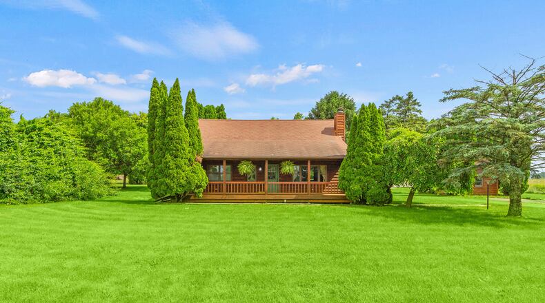 The front of the log cabin home in Pike Township has a full wooden front porch with railings. CONTRIBUTED PHOTOS