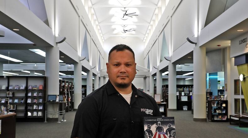 Chris Bussler holds his book in the Clark County Library Wednesday, Oct. 10, 2018. Bussler will be having a book signing at the library on November 7. BILL LACKEY/STAFF