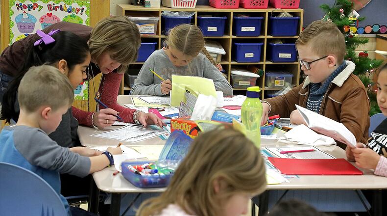 Second grade teacher Heidi Kottmyer helps students in her class at Donnelsville Elementary, part of the Tecumseh school district. BILL LACKEY/STAFF