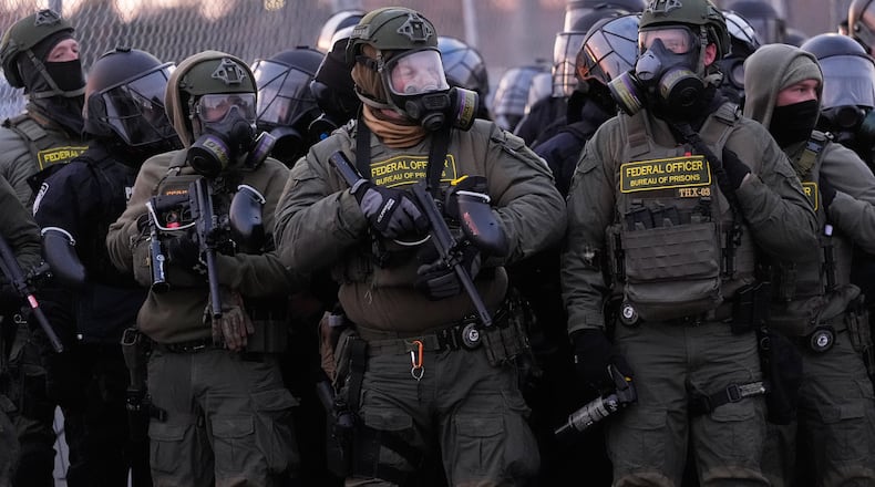 Federal officers stand outside the Bishop Henry Whipple Federal Building during a protest on Saturday, Jan. 17, 2026, in Minneapolis. (AP Photo/Yuki Iwamura)