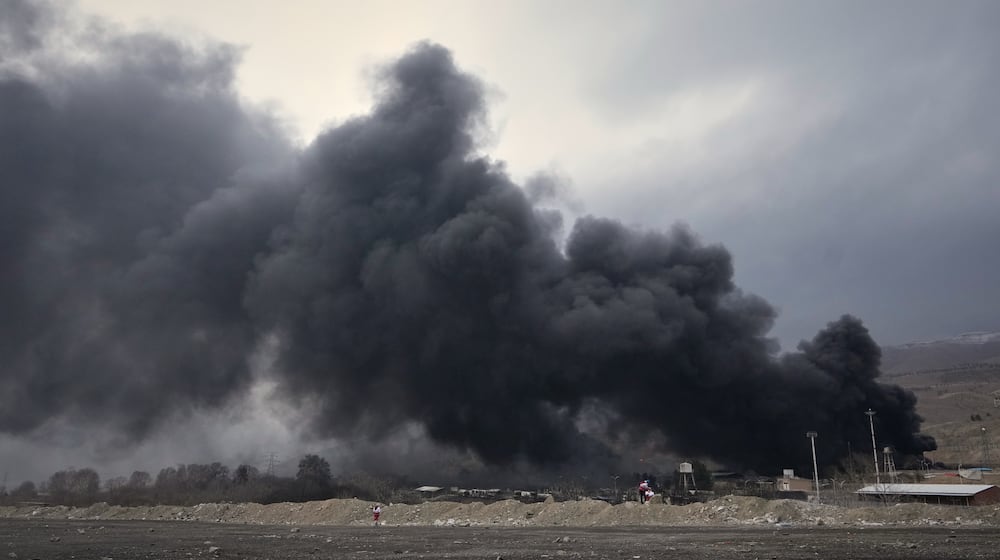A thick plume of smoke rises from an oil storage facility hit by a U.S.-Israeli strike late Saturday in Tehran, Iran, Sunday, March 8, 2026. (AP Photo/Vahid Salemi)