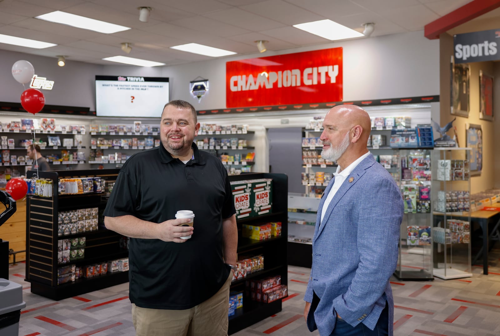 Champion City Games and Hobby owner Kenneth Seelig III, left, and Ohio Rep. Bernard Willis have a conversation during a grand opening for the expansion of the store on Friday, July 11, 2025, in Springfield. JOSEPH COOKE/STAFF