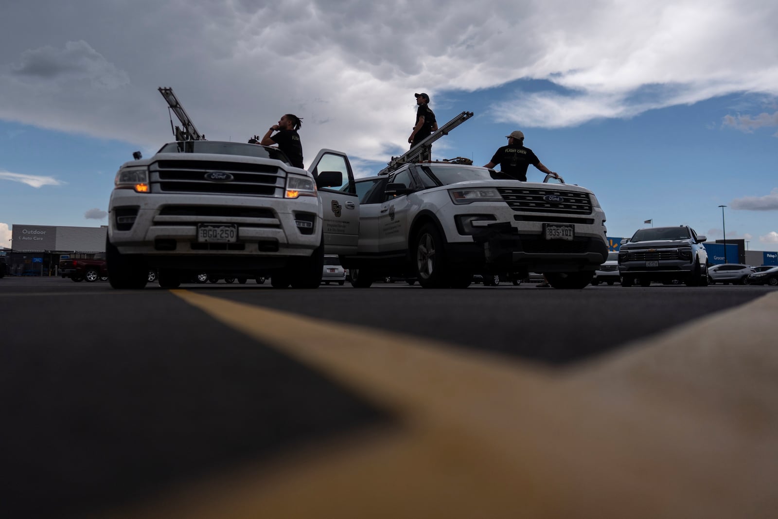 Members of the University of Colorado Boulder's Integrated Remote and In-Situ Sensing flight team stage in a Walmart parking lot before a Project ICECHIP operation Tuesday, June 3, 2025, in Atlus, Okla. (AP Photo/Carolyn Kaster)