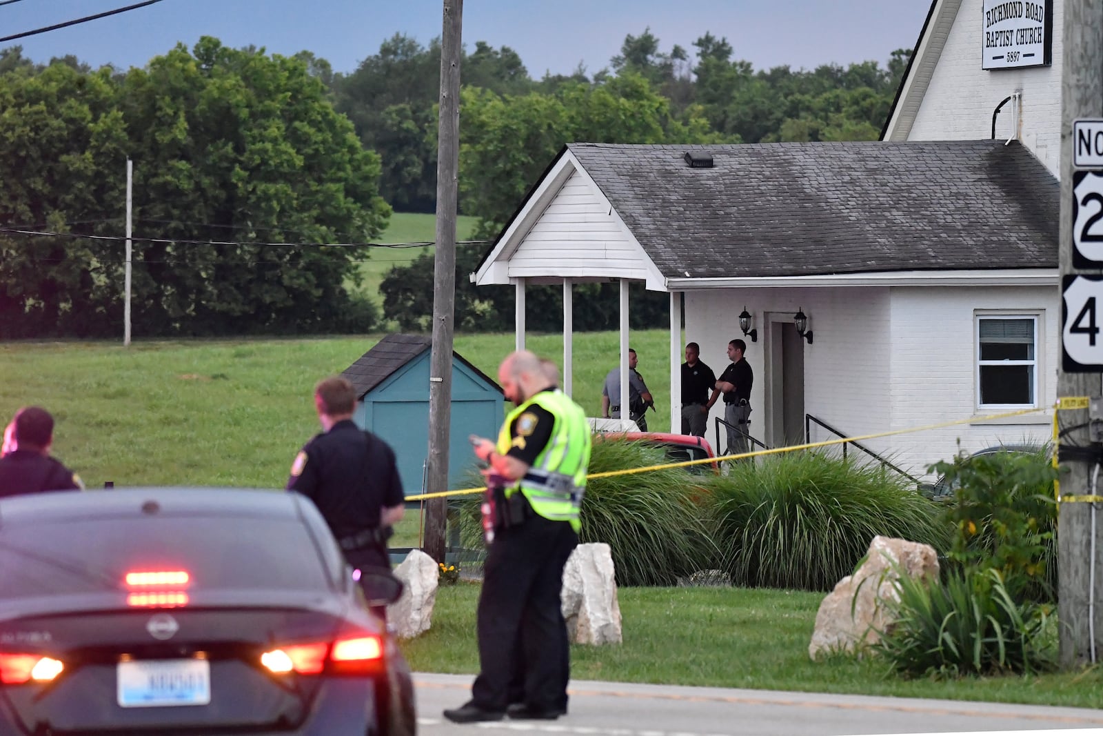 Police stand at the front of the Richmond Road Baptist Church as other officers maintain a perimeter following a shooting at the church in Lexington, Ky., Sunday, July 13, 2025. (AP Photo/Timothy D. Easley)