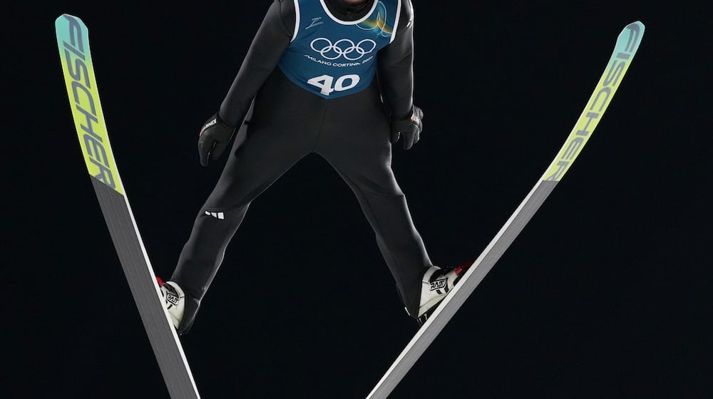 An athlete soars through the air during a ski jumping, men's normal hill, training session,at the 2026 Winter Olympics, in Predazzo, Italy, Thursday, Feb. 5, 2026. (AP Photo/Kirsty Wigglesworth)