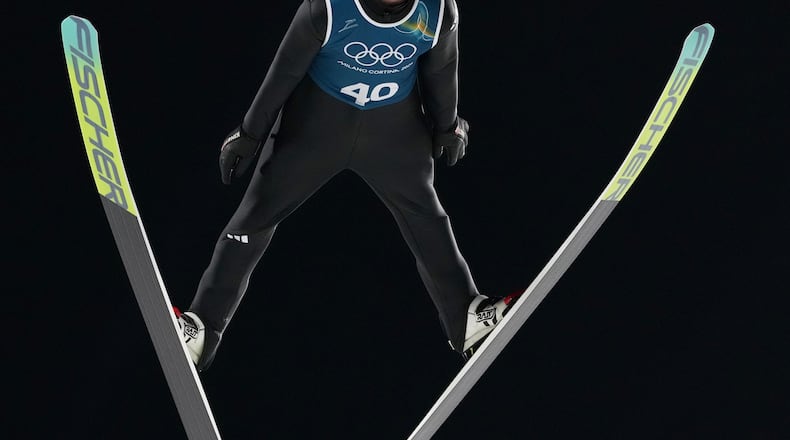 An athlete soars through the air during a ski jumping, men's normal hill, training session,at the 2026 Winter Olympics, in Predazzo, Italy, Thursday, Feb. 5, 2026. (AP Photo/Kirsty Wigglesworth)