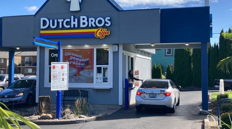 An employee of Dutch Bros Coffee in Salem, Ore., hands a drink to a customer on Wednesday, Sept. 15, 2021. AP FILE PHOTO