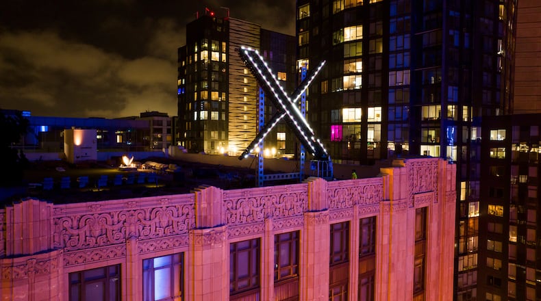 FILE - Workers install lights on an "X" sign atop the company headquarters in downtown San Francisco on July 28, 2023. (AP Photo/Noah Berger, File)