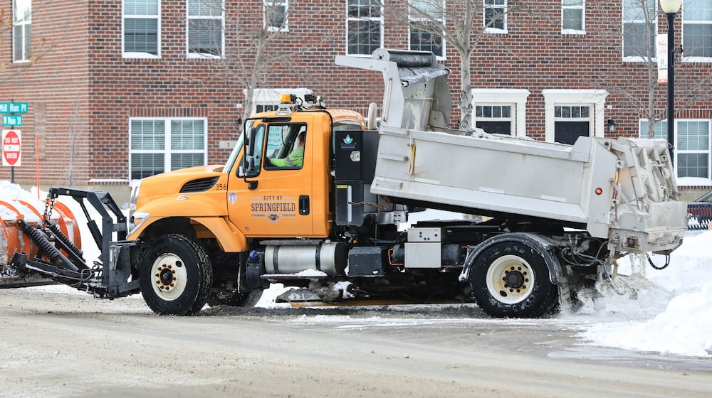 A City of Springfield plow truck spreads salt on Tuesday, Jan. 27 as it turns onto West Main Street. Snow removal efforts continued Tuesday after the city received 13 inches during the weekend's storm. BRYANT BILLING / STAFF