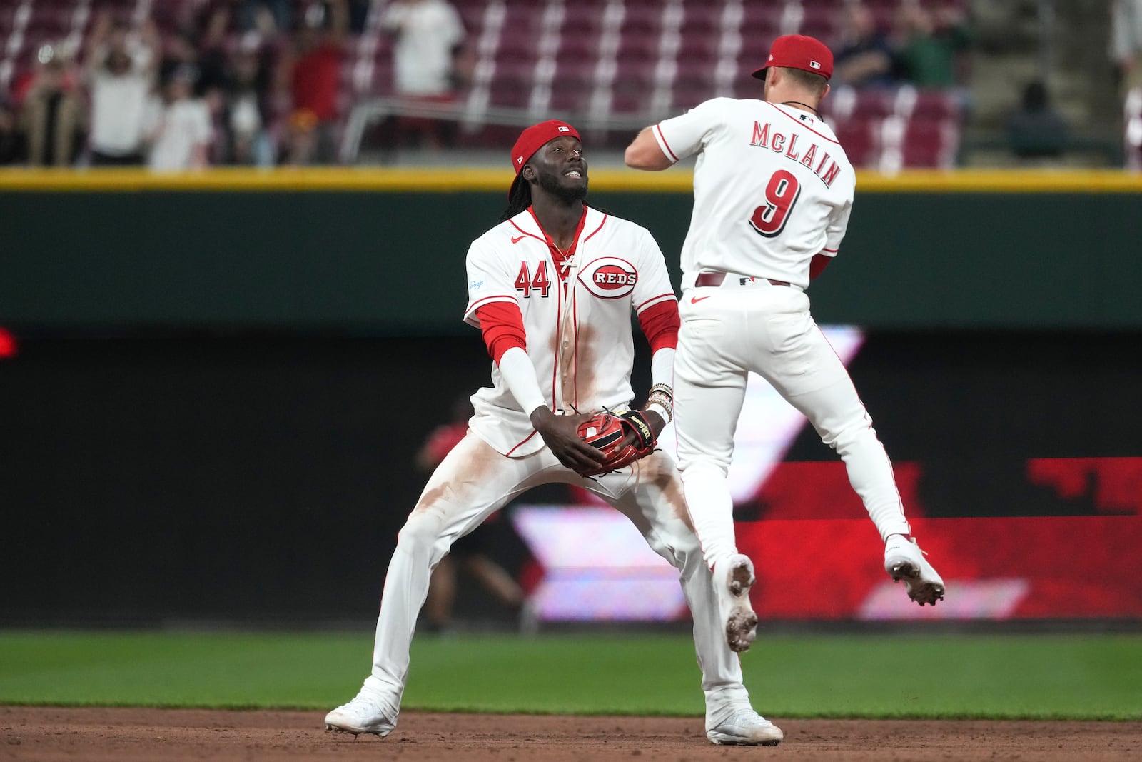 Cincinnati Reds second baseman Matt McLain, right, celebrates with shortstop Elly de la Cruz, center, at the end of a baseball game against the Pittsburgh Pirates, Monday, March 30, 2026, in Cincinnati. (AP Photo/Kareem Elgazzar)