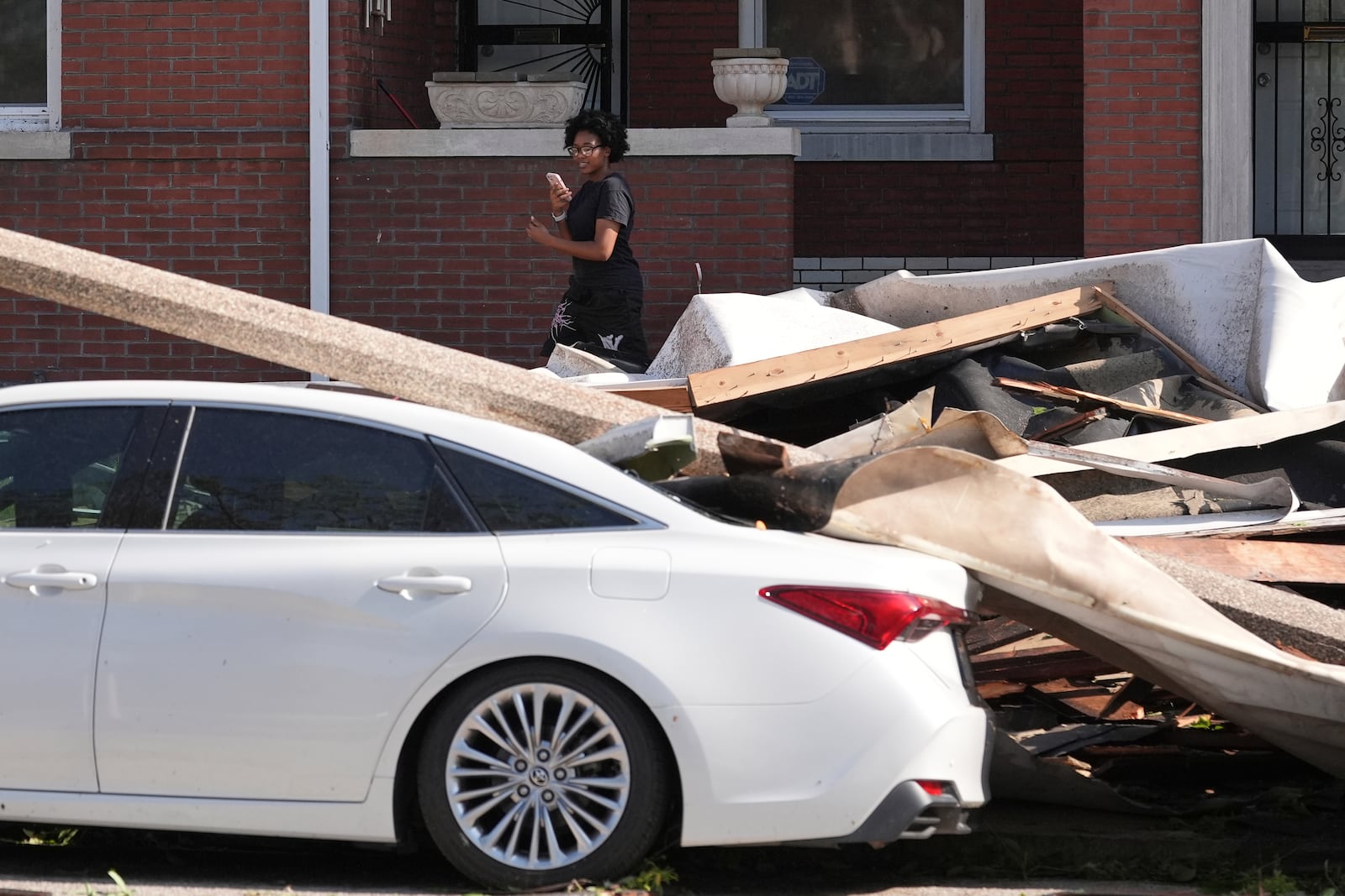 A person looks at damage caused by a severe storm moved through Friday, May 16, 2025, in St. Louis. (AP Photo/Jeff Roberson)