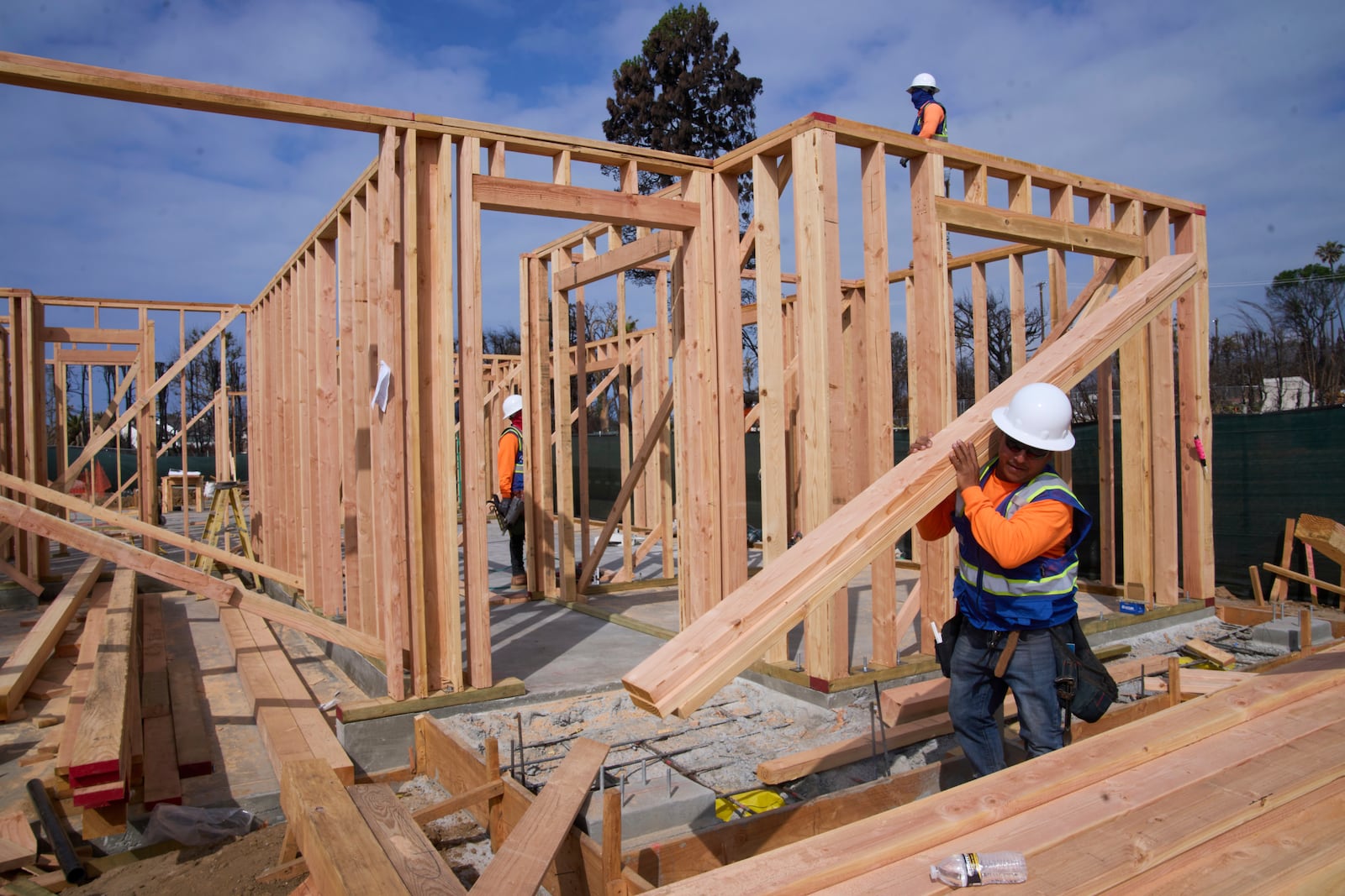 Workers rebuild a property destroyed by the Palisades Fire in the Pacific Palisades neighborhood of Los Angeles, Thursday, April 24, 2025. (AP Photo/Damian Dovarganes)