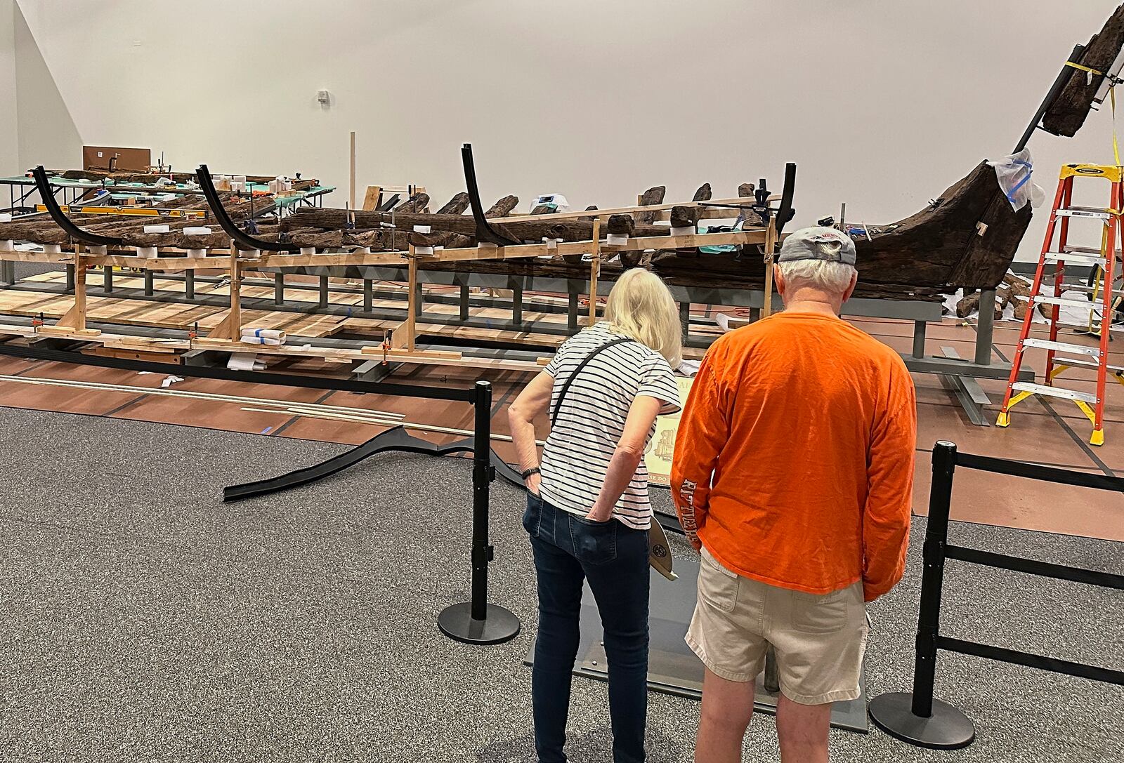 Visitors to the New York State Museum view a Revolutionary War-era gunboat that is being partially reconstructed, Friday, May 30, 2025, in Albany, New York. (AP Photo/Michael Hill)