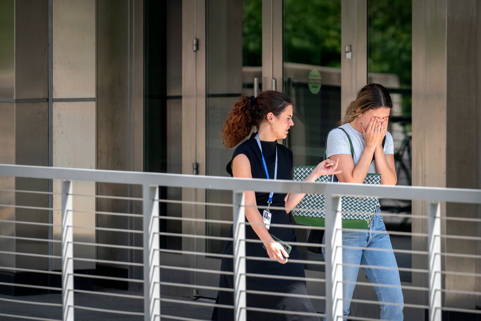 A woman reacts as she walks out of the State Department headquarters, Friday, July 11, 2025, in Washington. (AP Photo/Mark Schiefelbein).