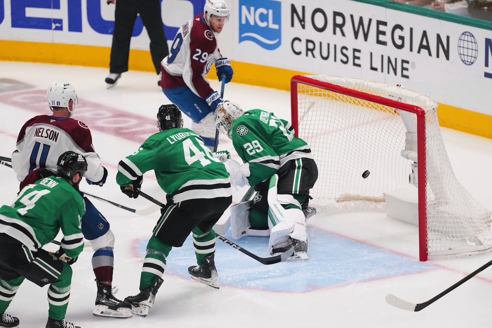 Colorado Avalanche's Nathan MacKinnon (29) sores against Dallas Stars' Jake Oettinger (29) as Brock Nelson (11), Dallas Stars' Jamie Benn (14) and Ilya Lyubushkin (46) look on in the third period in Game 7 of a first-round NHL hockey playoff series Saturday, May 3, 2025, in Dallas. (AP Photo/Julio Cortez)