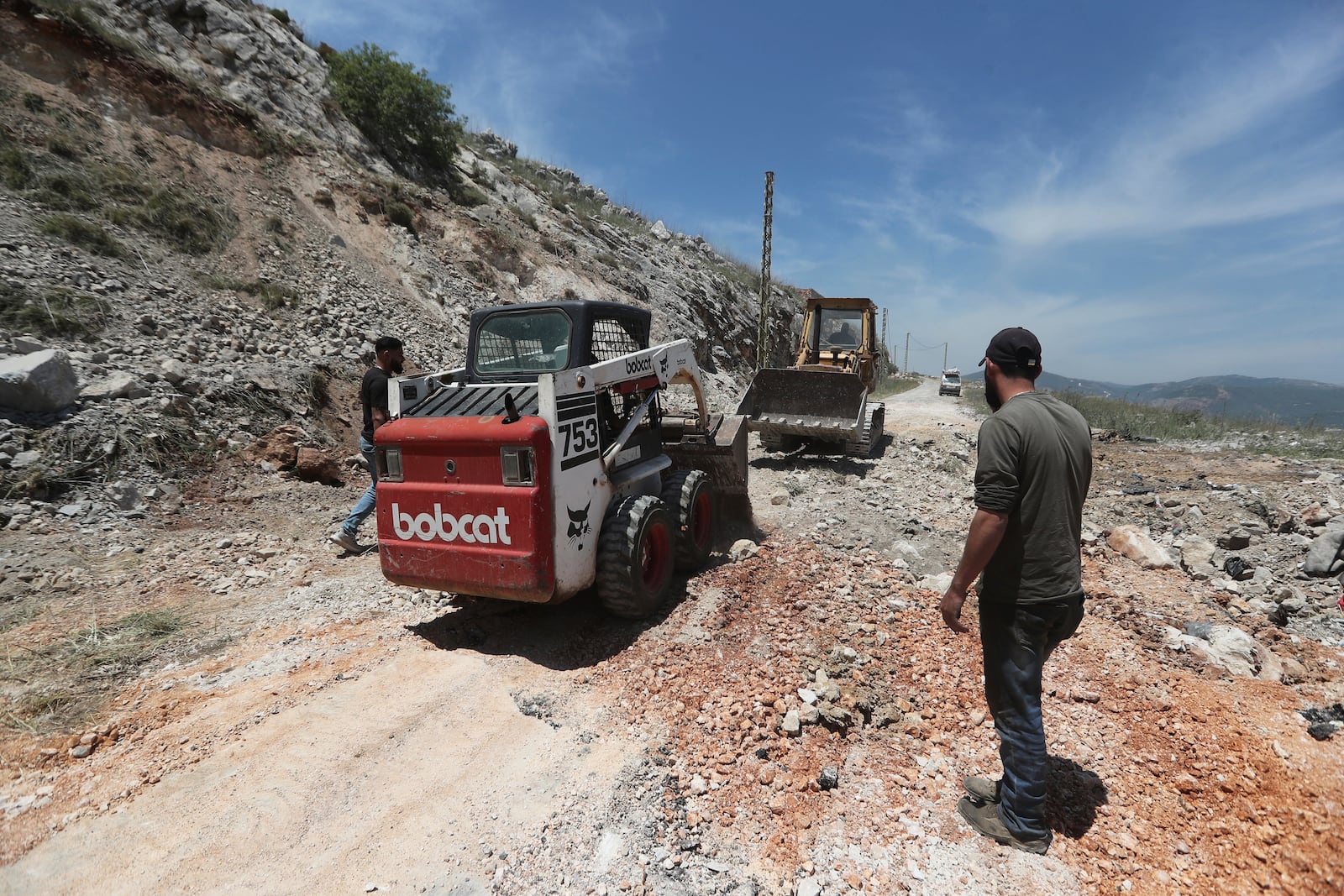 Workers close a crater following Israeli airstrikes that targeted hilltops near Nabatieh town, south Lebanon, Thursday, May 8, 2025. (AP Photo/Mohammed Zaatari)