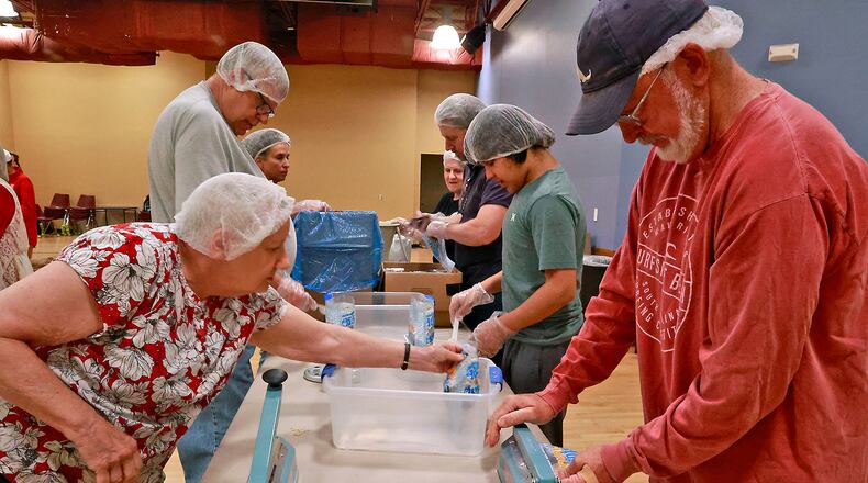 The older adults and employees at United Senior Services in Springfield were packaging nutritious meals for the starving children in Lesotho Friday, April 21, 2023. United Senior Services offers a variety of services for older Clark County residents, including meal programs, transportation aid, plus socialization opportunities such as this. BILL LACKEY/STAFF