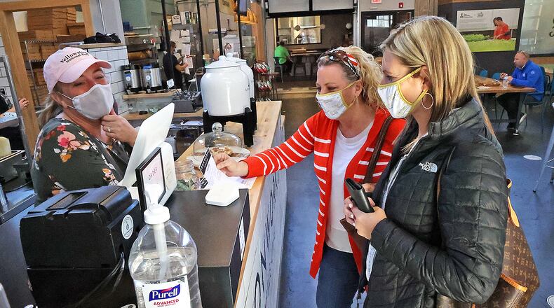 Karen Wonders, right, and Tara Winter order food from Wendy Snyder at Ironworks Waffle Cafe at the Market in COhatch Thursday. BILL LACKEY/STAFF