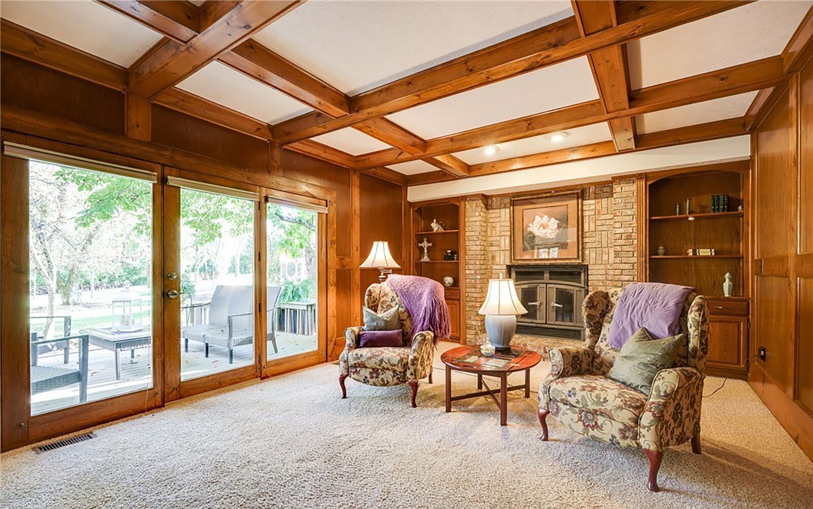 The family room has a beamed ceiling and a brick fireplace with stove insert surrounded by two built in bookcases. CONTRIBUTED