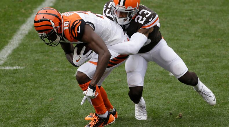 In this photo taken on Sunday, Sept. 29, 2013, Cleveland Browns cornerback Joe Haden, right, tackles Cincinnati Bengals A.J. Green during an NFL football game in Cleveland. With impressive performances the past two weeks, Cleveland's defense is establishing itself as one of the NFL's most dominant units. On Sunday, the Browns held the Bengals to just two field goals in a 17-6 win and Haden contained star wide receiver Green. (AP Photo/Tony Dejak)