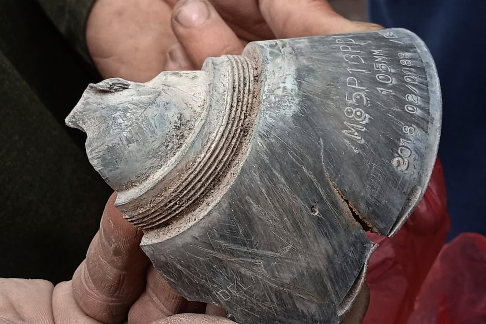 A local resident shows a piece of shell fired by Indian forces, at his damaged house in Haveli Kahuta, a district of Pakistan's administered Kashmir, Friday, May 9, 2025. (AP Photo/Rashid Ahmed)