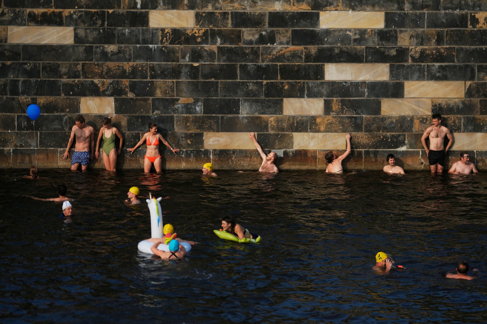 People swim in the river Spree to demand the lift of the hundred years old swimming ban at the river in Berlin, Germany, Tuesday, June 17, 2025. (AP Photo/Markus Schreiber)