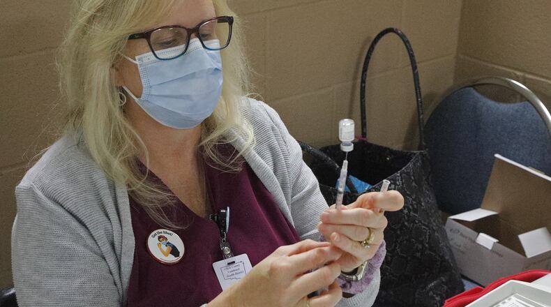 Annie Demana gets a COVID vaccine shot ready at the Clark County Combined Health District's vaccine center Wednesday. BILL LACKEY/STAFF