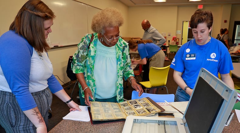 Jessica Baloun, left, and Alex Corpuz, right help Gayle Johnson scan her family photos Wednesday, June 21, 2023 during Black History Community Scan Day at the Clark County Library. BILL LACKEY/STAFF