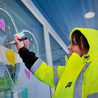 Taylor Rice, an employee at the Seven Brew on Main Street, paints the windows in preparation for Valentine’s Day, Friday, Feb. 6, 2026. CONTRIBUTED / BUCK CREEK PHOTOGRAPHY