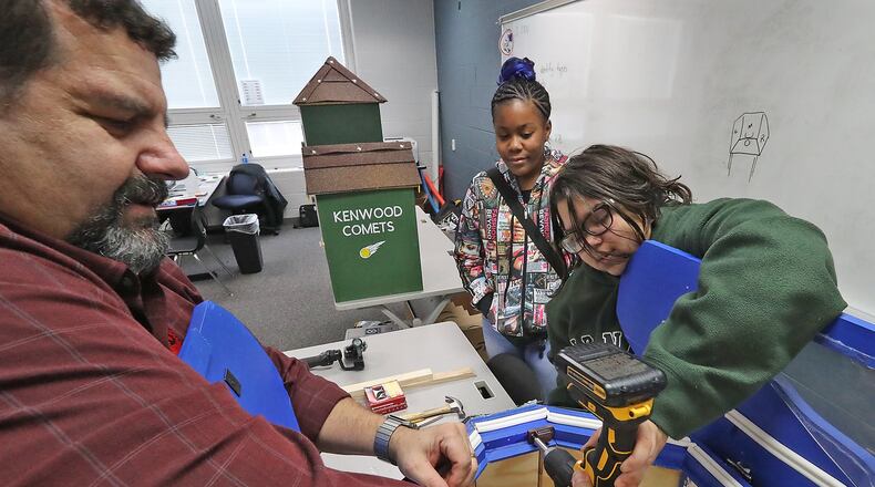 Hayward Middle School teacher, David Zeller, helps eighth graders, Natajha Castle, right, and Kailyn Greenip attach a door magnet on the “House of Knowledge” that they and the other students in Zeller’s design and modeling class made. Bill Lackey/Staff